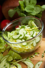 salad in a bowl of tomato, cucumber, cabbage vegetables for salad in the background, selective focus
