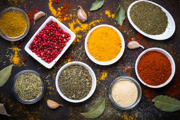 Various spices in a bowls on stone table.