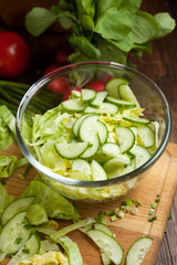 salad in a bowl of tomato, cucumber, cabbage vegetables for salad in the background, selective focus