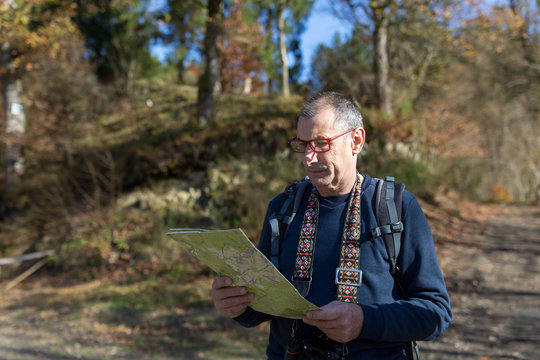 Senior male with map in nature