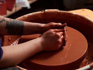 production process of pottery. Forming a clay mug on a potter's wheel.