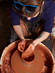 production process of pottery. Forming a clay mug on a potter's wheel.