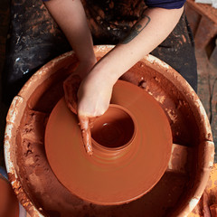 production process of pottery.  Forming a clay mug on a potter's wheel.