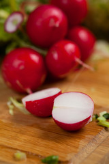 Fresh red radish in the beam with leaves on the old dark wooden background, selective focus