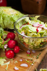 salad in a bowl of tomato, cucumber, cabbage vegetables for salad in the background, selective focus