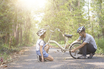 Happy father helped his daughter repair the bike, togetherness relaxation concept