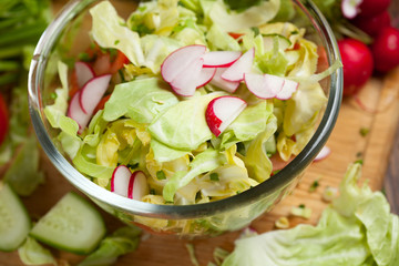 salad in a bowl of tomato, cucumber, cabbage vegetables for salad in the background, selective focus