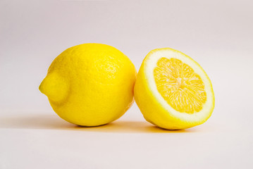 Lemon whole and in a cut on a white background. Studio photo.