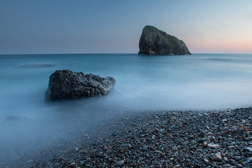 Scenic sunset on a rocky seashore on long exposure