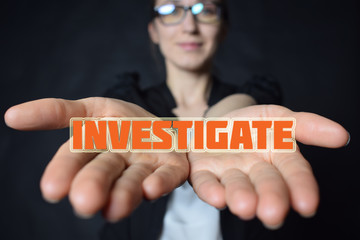 In the hands of a businessman the inscription:INVESTIGATE