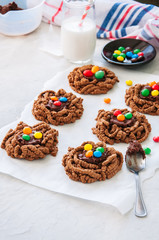 Chocolate bird's nest cookies decorated with colorful candies on a white background.