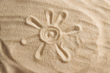 The sun is painted in the sand. Beach background. Top view. The concept of summer, summer kanikkuly, vacation, holydays.