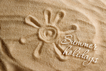 The heart is painted in the sand and the inscription is summer holidays. Beach background. View from above. The concept of summer, summer kanikkuly, vacation, holydays.