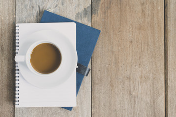 top view a cup of coffee put on note book 