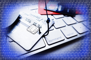 Phishing concept with credit card into a fishing hook, suggesting cyber crime, with digital binary data as abstract background
