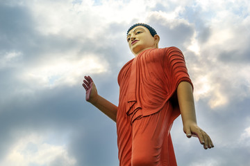 Fototapeta na wymiar large statue of Buddha rises above the city against a sky with clouds