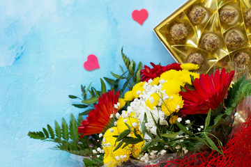 A wedding story or background Mother's Day. Basket bouquet of gerbera with chrysanthemums and sweets on a stone background or slate with copy space. Free space for your congratulations.