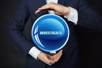 In the hands of a businessman, a neon circle with the inscription:INVESTIGATE