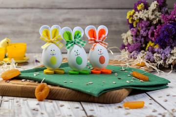 Easter eggs decorated with bunnies on wooden background