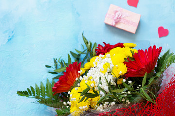 A wedding story or background Mother's Day. Basket bouquet of gerbera with chrysanthemums and present on a stone background or slate with copy space.