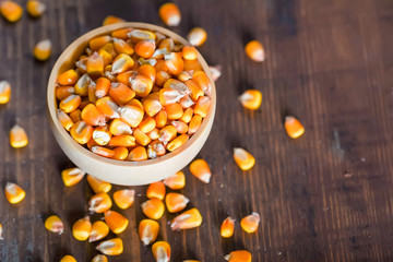 Close up corn seeds in bowl on wooden table