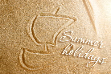 The boat with a sail is painted on the sand and the inscription is a summer holiday. Beach background. View from above. The concept of summer, summer kanikkuly, vacation, holydays.
