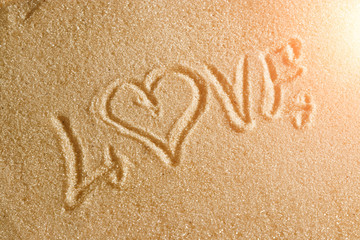 The word love is painted in the sand. Beach background. Top view. The concept of summer, summer kanikkuly, vacation, holydays.
