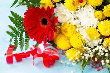 A wedding story or background Mother's Day. Basket bouquet of gerbera and chrysanthemums on a stone background or slate.