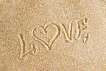 The word love is painted in the sand. Beach background. Top view. The concept of summer, summer kanikkuly, vacation, holydays.