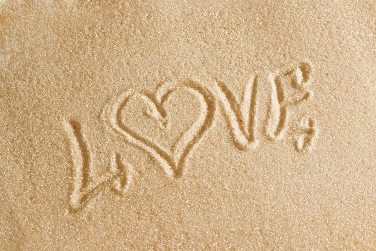 The word love is painted in the sand. Beach background. Top view. The concept of summer, summer kanikkuly, vacation, holydays.