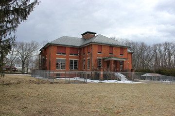 Old abandoned and boarded up brick asylum hospital building