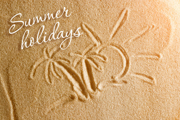 Palm trees are painted in the sand and the inscription is summer holidays. Beach background. View from above. The concept of summer, summer kanikkuly, vacation, holydays.