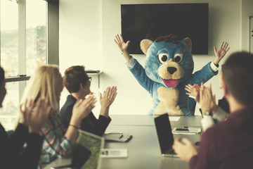 boss dresed as bear having fun with business people in trendy office