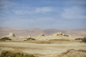 Fototapeta na wymiar The old mountains of the Negev desert of different colors on the background of the blue sky with clouds