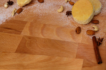 cakes with nuts, anise, cinnamon, sugar powder lie on wooden board.