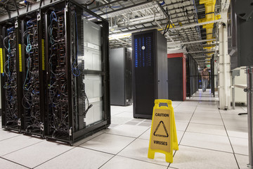 Racks of servers aligned in rows in a large computer server farm.