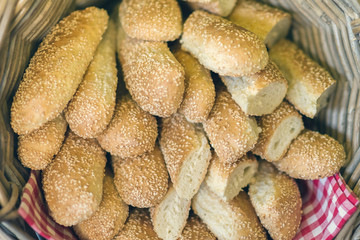 Basket with fresh bread loaves on the background of bottles of wine