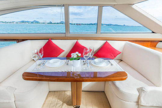 Fototapeta Luxury lunch table setting on a luxury yacht interior comfortable cabin expensive wooden design for holiday recreation tourism travel and vacation concept