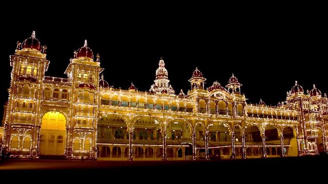 Pan view of splendid Mysore Palace light up at night in Karnataka, India. Historic landmark, popular tourist attraction