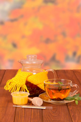 Pitcher and Cup of hot tea, honey and spoon- spindle on table