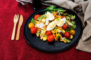 Salad of pasta, egg, smoked salmon tartare, salad and tomato, with a citrus vinaigrette sauce.