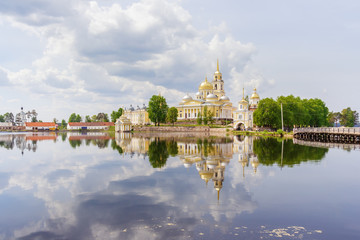 Temples of the Nilo-Stolobenskaya desert with reflection in the lake Seliger