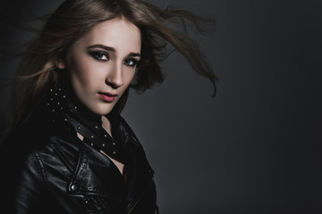 Fototapeta na wymiar Beautiful model in black leather jacket in studio