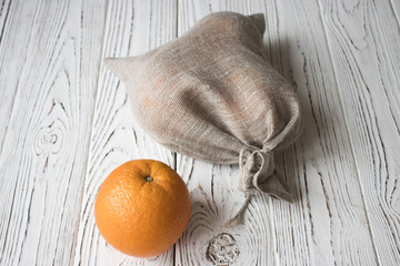 oranges in a small bag on a wooden table closeup