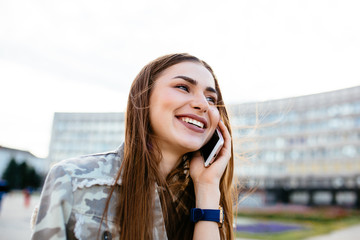 Cheerful girl talking on mobile phone, outdoors