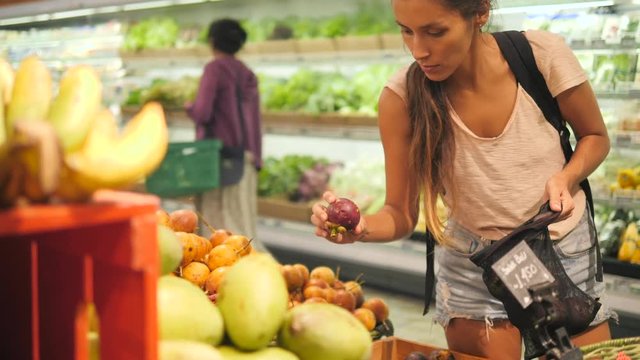 Young Mixed Race Woman Shopping without Plastic Bags in Grocery Store. Vegan Zero Waste Girl Choosing Fresh Exotic Fruits in Supermarket. 4K.