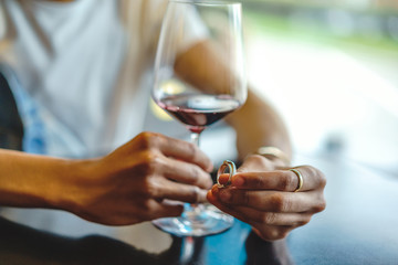 Close-up view of male hands with wineglass and rings