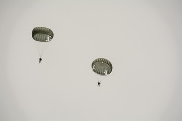 Two parachutes float in the sky.