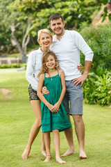 Fototapeta premium happy family embracing in green park and looking at camera