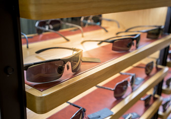 Various of sun glasses in the shop display shelves.